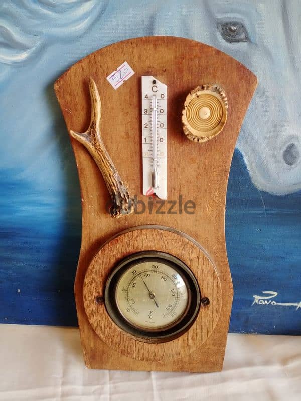 ميزان حرارة وساعة ضغط جوي وقطعتين قرن غزال على قاعدة خشب 0