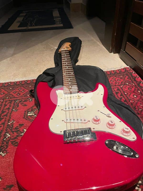 red on white stratocaster with amp and cables 0