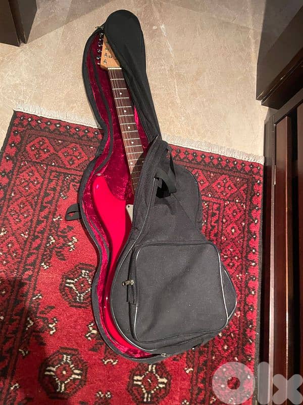 red on white stratocaster with amp and cables 1