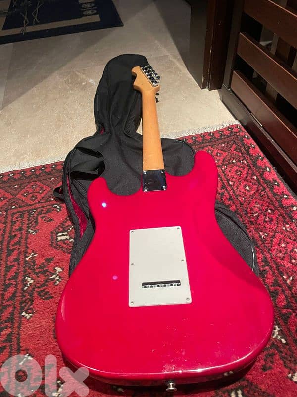 red on white stratocaster with amp and cables 2