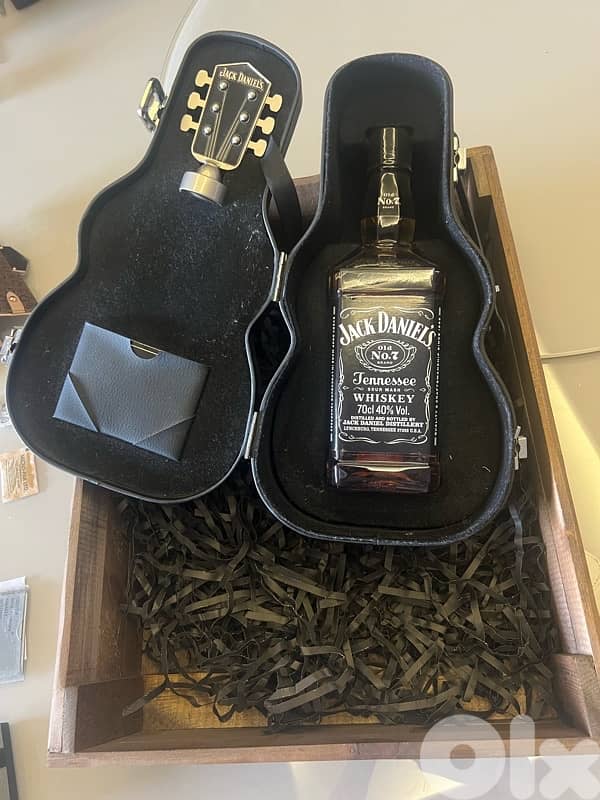 jack Daniel’s bottle in a guitar box and a wooden box 0