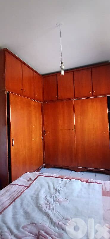 2ouda : 8zene ta5et comondina / غرفة نوم: تخت، خزانه، وكومودينا.