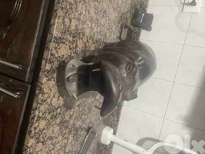 خشب منحوت يدويًا (غالبًا خشب إفريقي مثل الأبنوس أو الماهوغاني