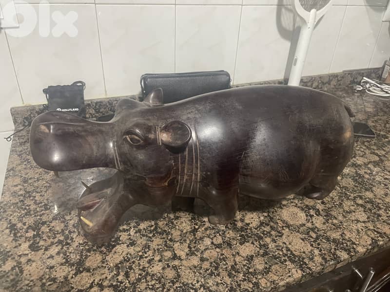 خشب منحوت يدويًا (غالبًا خشب إفريقي مثل الأبنوس أو الماهوغاني 3