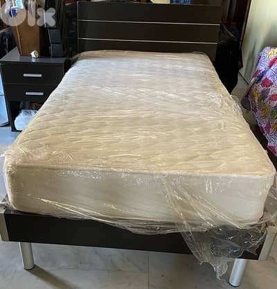 bedroom with mattress and side table