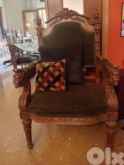 Elegant antique-style carved wooden armchair with lion head details.