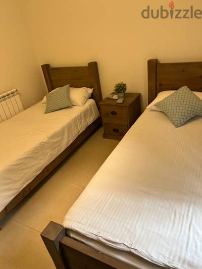 bedroom two besds with a bedside table and matresses never been used